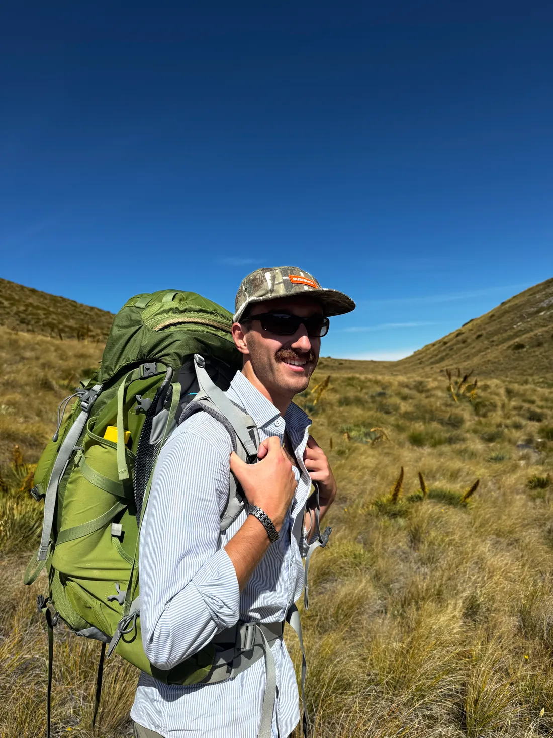 Harrison O'Connor hiking with a pack in the tussock hills